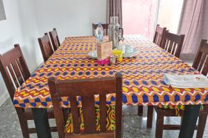 uma mesa com uma toalha de mesa amarela e azul em Beautiful Villa with Swimming Pool in Assinie em Mafia