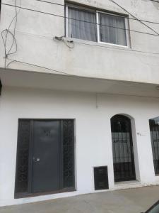 un edificio blanco con puertas y ventanas negras en AQUA, en Puerto Madryn