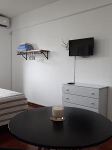 Habitación con mesa con vela y TV. en Departamento Estudio Alem y San Martin en Mendoza