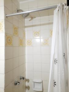 baño con ducha con cortina blanca en Departamento Estudio Alem y San Martin en Mendoza