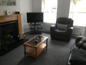 uma sala de estar com lareira e televisão em Glenview Self Catering Holiday Home em Portrush