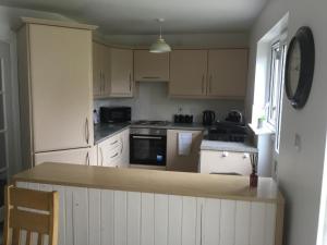 uma cozinha com armários brancos e uma bancada em Glenview Self Catering Holiday Home em Portrush