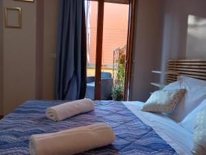 1 dormitorio con 1 cama con 2 toallas en B&B del Viale, en LʼAquila
