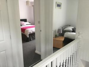 um corredor que leva a um quarto com uma cama em Glenview Self Catering Holiday Home em Portrush