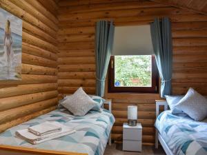 a bedroom with two beds in a log cabin at Felmoor Park - Mystic Falls in Felton