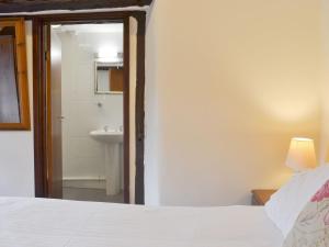 a bedroom with a bed and a bathroom with a sink at Mill Apartment - Ukc3784 in West Down