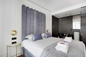 a bedroom with a large white bed with towels on it at Couples Getaway Unit with Jacuzzi - City Center in Paris