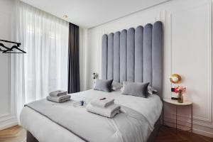 a bedroom with a large white bed with towels on it at Couples Getaway Unit with Jacuzzi - City Center in Paris
