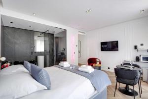 a bedroom with a large white bed and a desk at Couples Getaway Unit with Jacuzzi - City Center in Paris