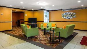 una sala de espera con sillas verdes y TV en Studios & Suites 4 Less Charlotte, en Charlotte