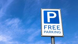 un letrero de aparcamiento gratuito frente a un cielo azul en Studios & Suites 4 Less Charlotte en Charlotte