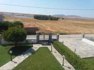 a view of a house with a gate and a field at Irini's Appartment 2 in Néa Koútali