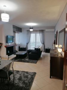 ein Wohnzimmer mit einem Sofa und einem Tisch in der Unterkunft Thira Apartment near Athens Airport in Spáta