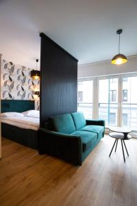 um quarto com uma cama e um sofá azul em Sunny Apartment Lwowska 10 na Cracóvia