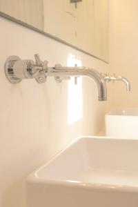 a bathroom with a sink and a faucet at Cycladic Villa Kamari in Kampos Paros