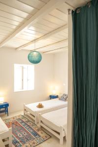 a bedroom with two beds and a green curtain at Cycladic Villa Kamari in Kampos Paros