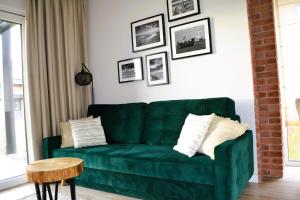 a green couch in a living room with a table at Norda Loft in Dębki