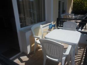 a white table and chairs on a balcony at Irini's Appartment 2 in Néa Koútali