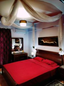 a bedroom with a red bed and a mirror at Thira Apartment near Athens Airport in Spáta