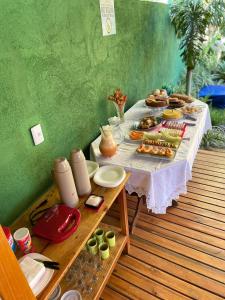 una mesa con comida en una terraza de madera en Encanto do mar residencial, en Caraíva