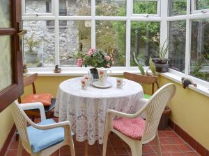 a table and chairs in a room with windows at The Gazebo in Marazion