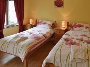 a bedroom with two beds and two lamps on tables at The Gazebo in Marazion