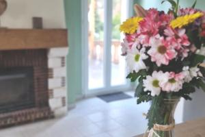 um vaso de flores sentado numa mesa numa sala de estar em La Maison des Délices em Dosches