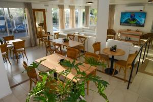 a restaurant with tables and chairs and a couch at HAS Hotel Boutique in Bella Unión