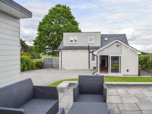a house with a patio with two blue chairs at The Wee White Cottage in Bannockburn