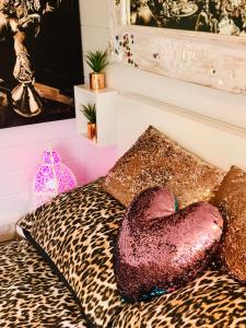 Habitación con cama de leopardo y almohada cardiaca. en Ibiza Casa en Kent