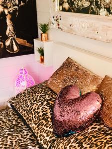a room with a leopard bed with a heart pillow at Ibiza Casa in Kent