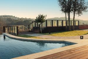 a swimming pool with a deck and stairs next to the water at Casa da Ribeira in Marco de Canavezes