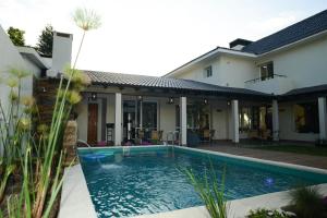 a house with a swimming pool in front of a house at HAS Hotel Boutique in Bella Unión