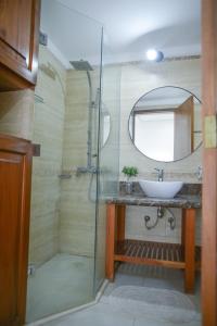 a bathroom with a sink and a shower with a mirror at HAS Hotel Boutique in Bella Unión