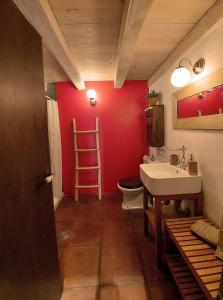 uma casa de banho com um lavatório e uma parede vermelha em Casa Corazón de piedra en el Río Dulce em Aragosa