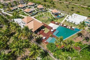 - une vue aérienne sur une maison avec une piscine et des palmiers dans l'établissement Tuju Boutique Hotel, à Passo de Camarajibe