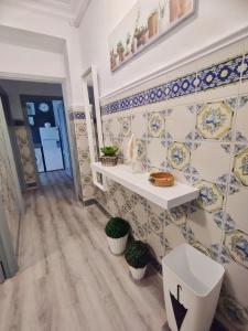 Baño con azulejos azules y blancos en la pared en Apartamento Ana Maria en San Juan del Puerto