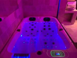 a pink bath tub with purple lights in a bathroom at Le Jacuzzi in Rouen