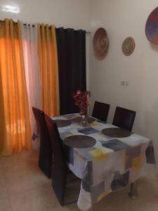 Villa chez Julien في Rufisque: طاولة طعام مع كراسي وطاولة مع مفرش