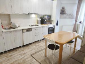 a kitchen with white cabinets and a wooden table at Inessa Center Guest PenthHouse in Chişinău