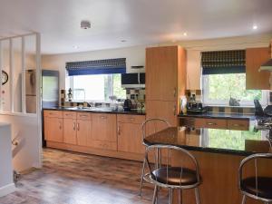 a kitchen with wooden cabinets and a counter top at Treetops in Bowness-on-Windermere