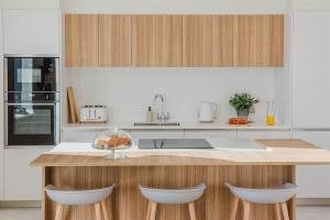 a kitchen with a counter with three stools at 7 Cliff Edge in Newquay