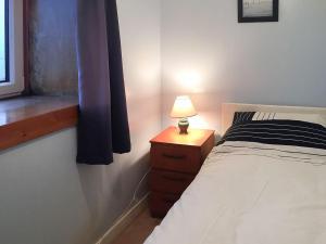 1 dormitorio con 1 cama y 1 mesa con lámpara en Tigh Mairi en Tarbert