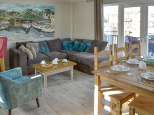 a living room with a couch and a table at Davids Island in Wroxham