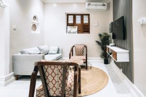 ein Wohnzimmer mit einem Sofa und einem TV in der Unterkunft Najma's villa in Stone Town