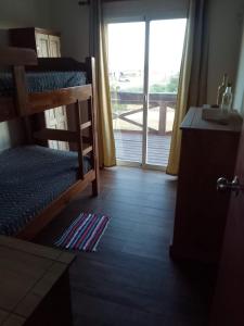 a room with bunk beds and a door with a window at La Quijotada in Punta Colorada