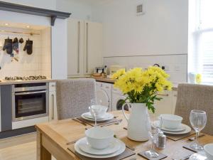 una cucina con tavolo con fiori gialli in vaso di Fern Spree a Buxton