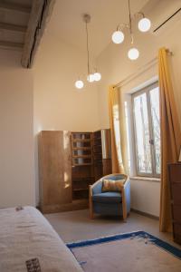 a bedroom with a bed and a chair and a window at Domaine Cap Rubis in Paradou