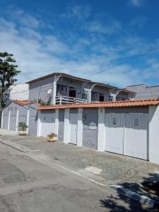 un edificio con una valla blanca y una casa en Casa duplex EM CONDOMINIO ambiente familiar, en Cabo Frío