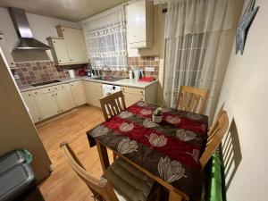 a kitchen with a table and chairs and a kitchen with white cabinets at River Bay in Cardiff